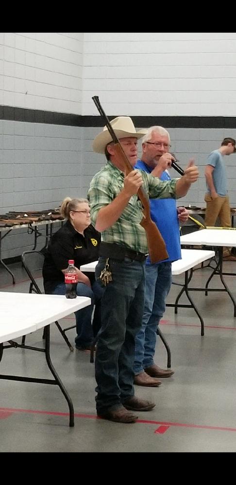 man holding rifle for auction