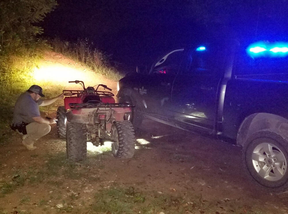 Searcy County deputy examining the vehicle identification number of an ATV.