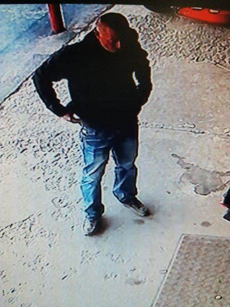 man standing in black jacket and jeans with hands on hips