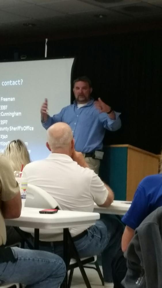 man in blue shirt speaking to audience